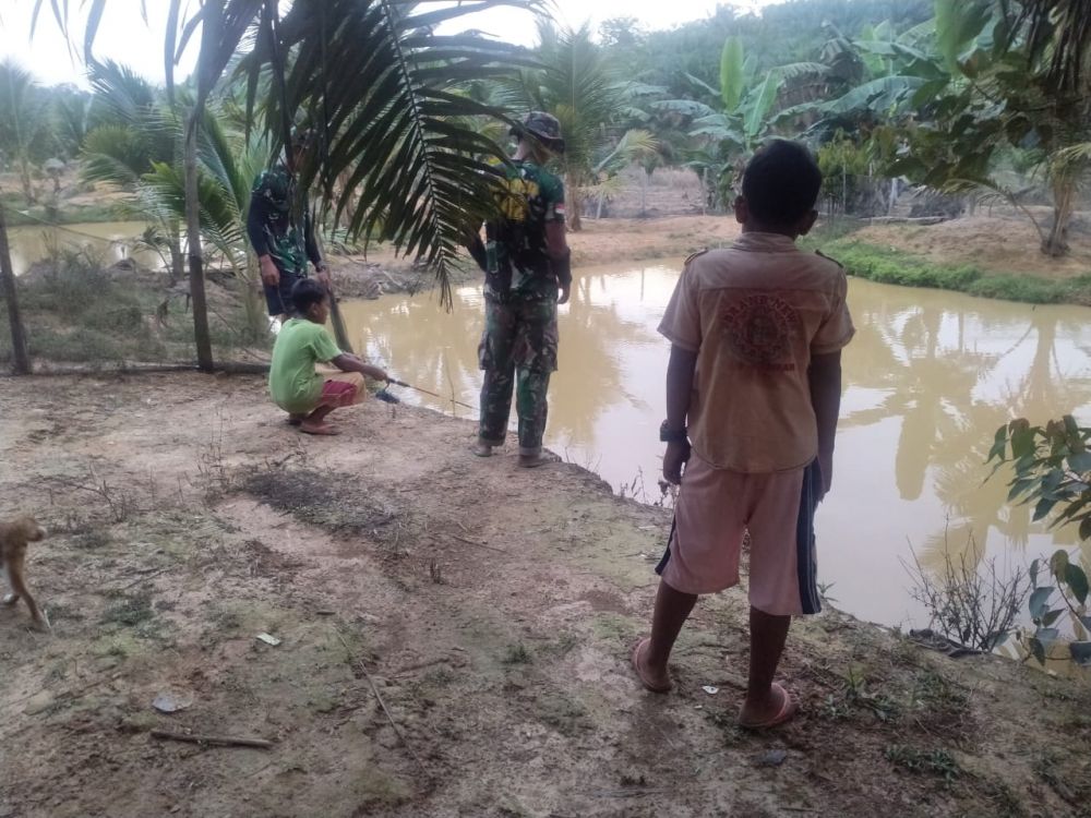 Manfaatkan Waktu Luang, Satgas dan Anak-anak Mancing Ikan 