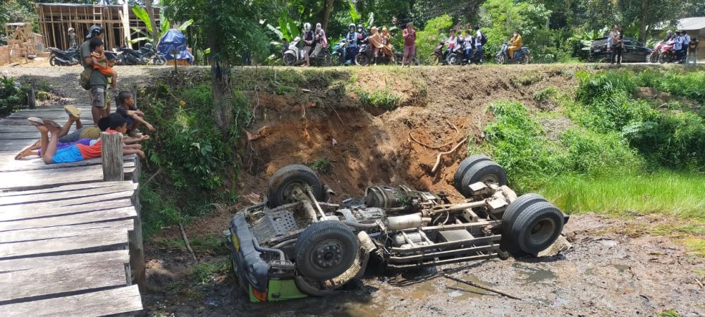 Hindari Sepeda Motor, Mobil Dump Truk Terguling ke Dalam Kanal