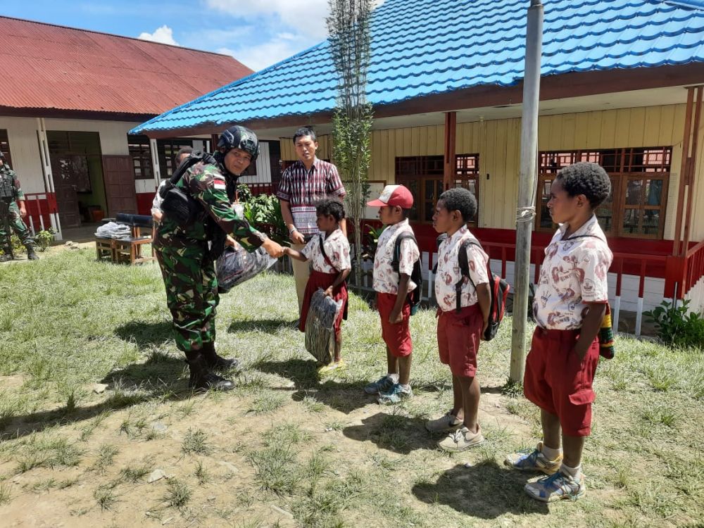 Satgas Pamtas Yonif Raider 142/KJ Bagikan Tas Sekolah di SD Negeri Karubaga 