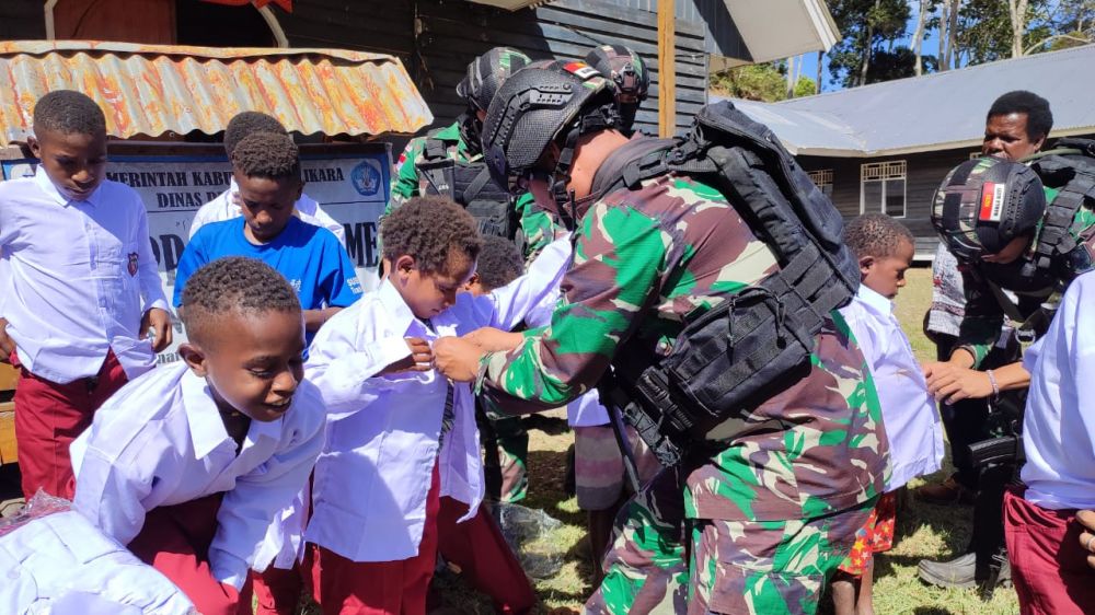 TNI Peduli Anak Papua, Satgas Yonif 142/KJ Bagikan Pakaian Seragam Kepada Siswa di Perbatasan