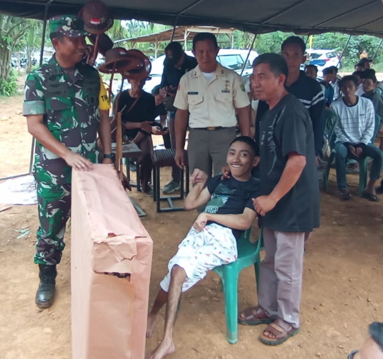 Ketua Tim Wasev TMMD Serahkan Bantuan Kursi Roda kepada Penderita Lumpuh di Desa Suka Maju