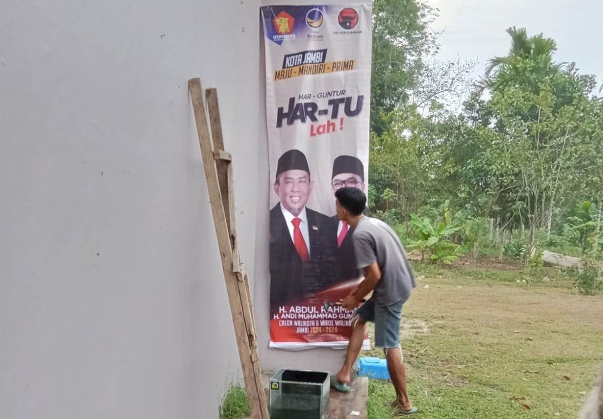 Kompaknya Pasangan Suami Istri di Paal 10 Ini Pasang Baliho H Abdul Rahman-Guntur Muchtar