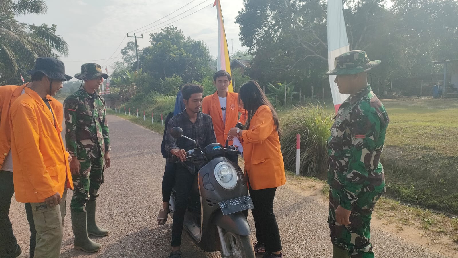 Satgas TMMD ke-121 Kodim 0415/Jambi dan Mahasiswa UNJA Bagikan Bendera Merah Putih kepada Warga