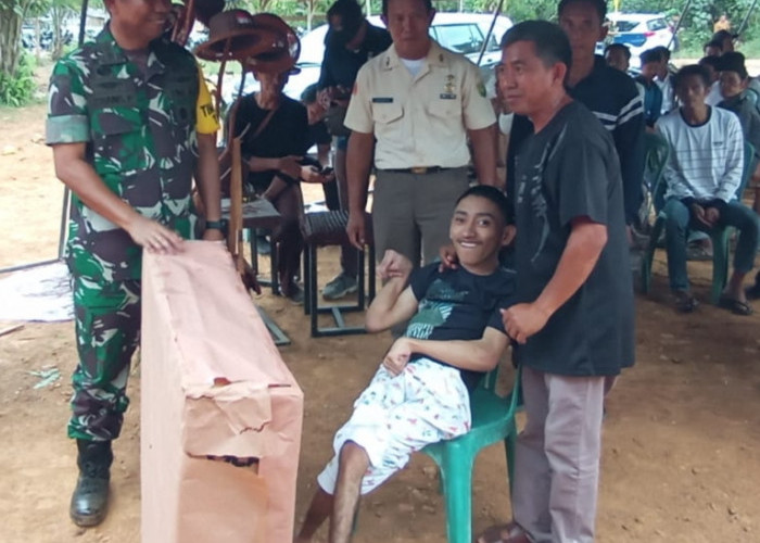 Ketua Tim Wasev TMMD Serahkan Bantuan Kursi Roda kepada Penderita Lumpuh di Desa Suka Maju