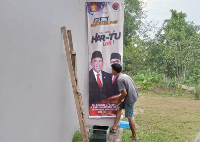 Kompaknya Pasangan Suami Istri di Paal 10 Ini Pasang Baliho H Abdul Rahman-Guntur Muchtar